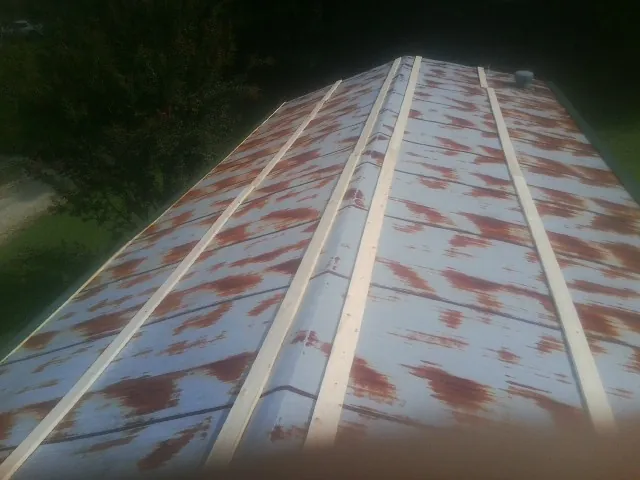 Rusted metal roof panels with new wood purlins before replacement — Storm Damage Roof Repair in Ward by Roofing Brothers