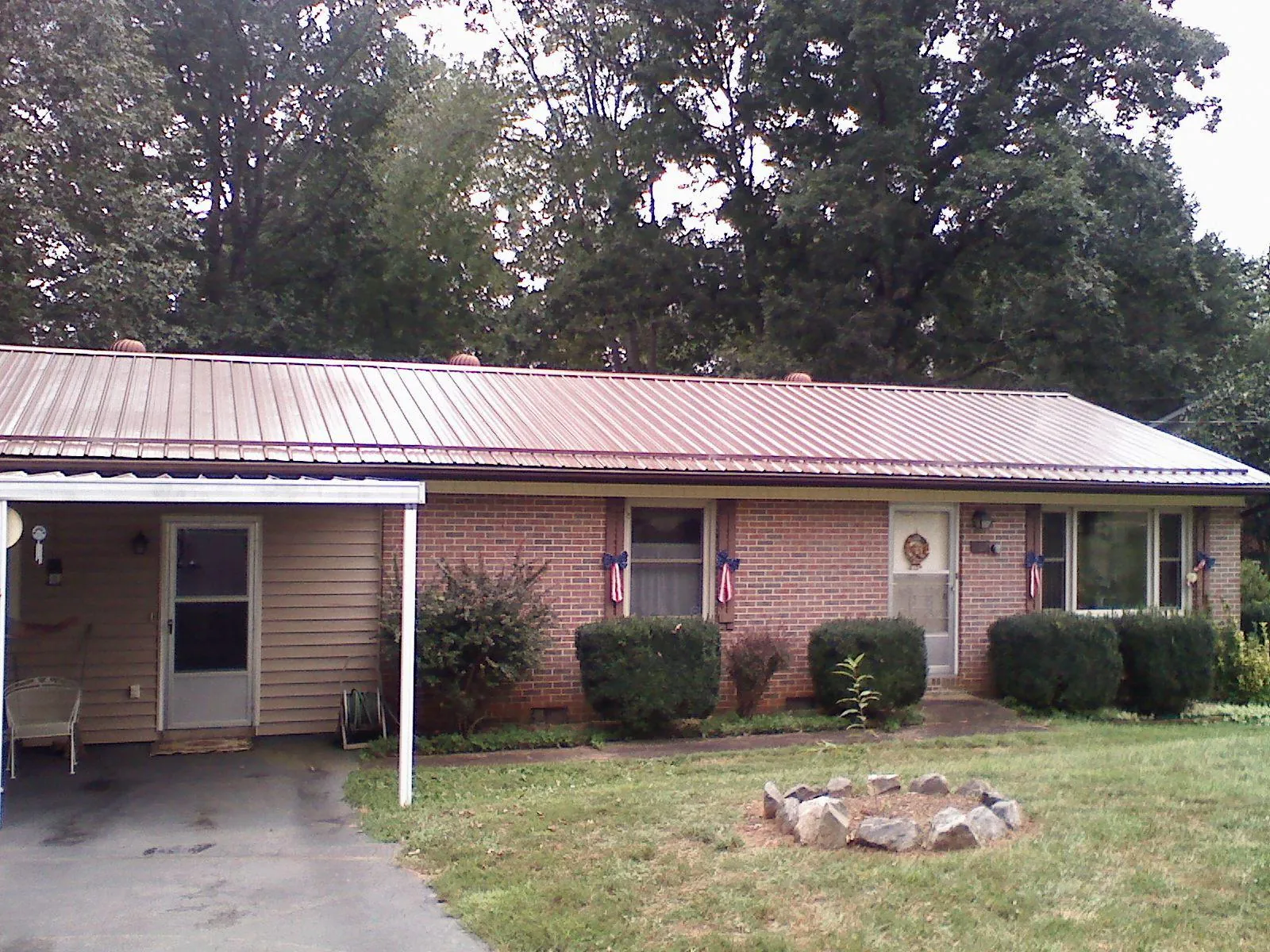 Bronze metal roof and carport on a brick ranch home — Roof Repair work by our crew in Ward